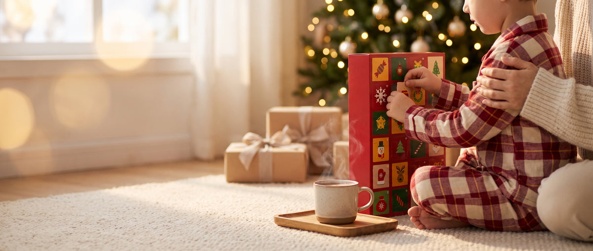 Kind opent een deurtje van de adventskalender bij de kerstboom