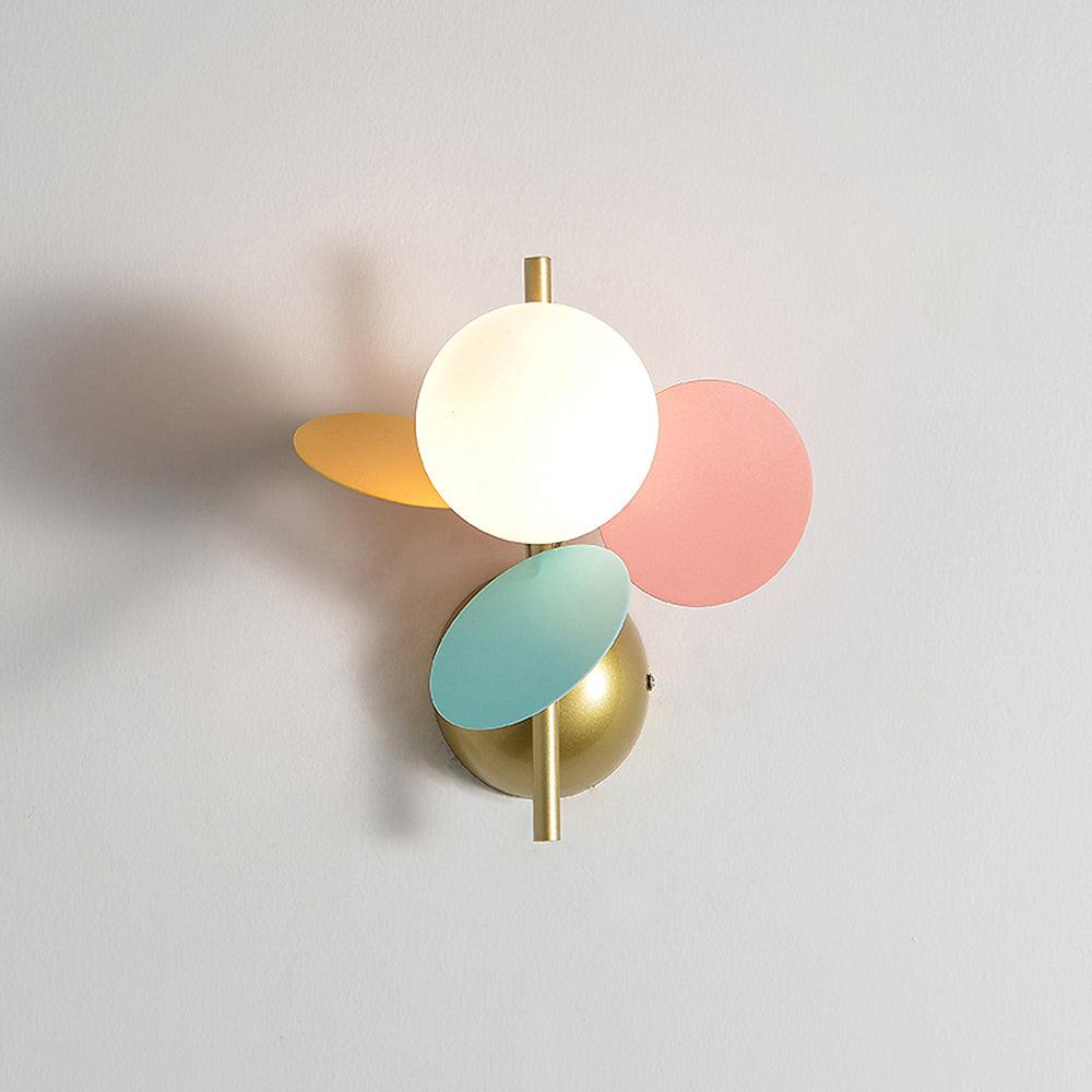 Grijze macaron wandlamp naast het bed