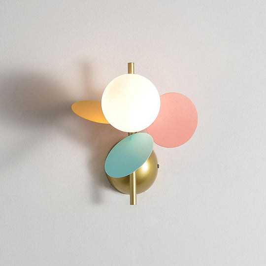 Grijze macaron wandlamp naast het bed